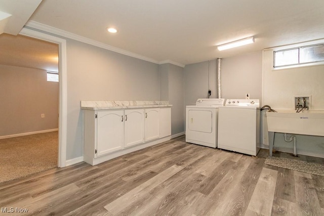 laundry room with light hardwood / wood-style floors, sink, ornamental molding, and independent washer and dryer