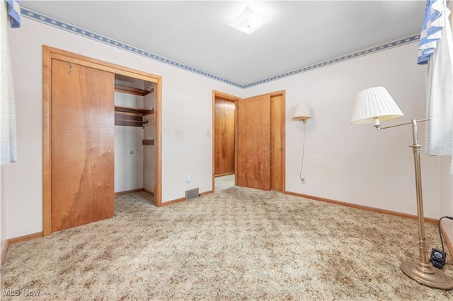 unfurnished bedroom with light carpet and a closet