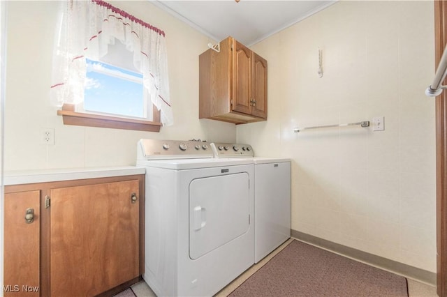 washroom featuring cabinets, crown molding, and washer and clothes dryer