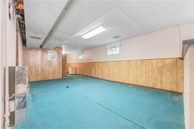 basement featuring wood walls