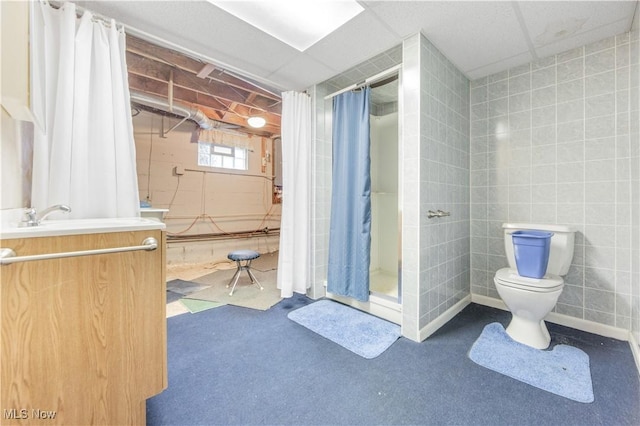 bathroom with walk in shower, vanity, toilet, and tile walls