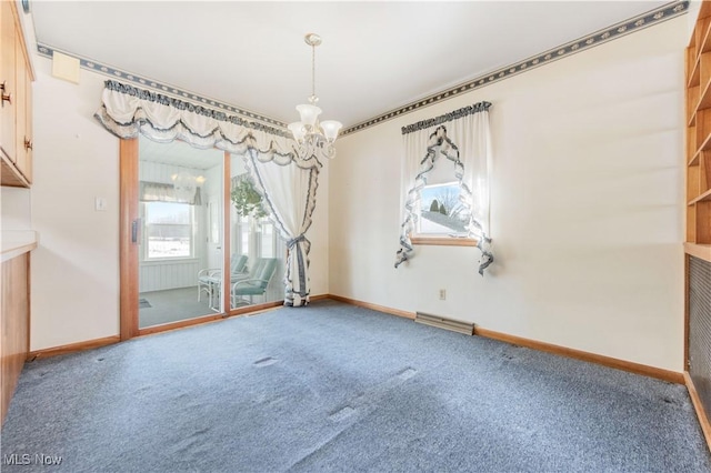 empty room with carpet and a notable chandelier