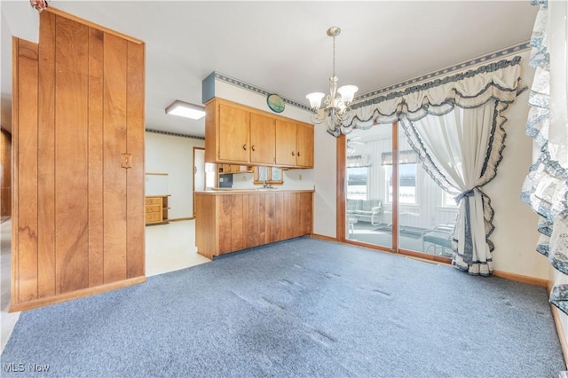 kitchen featuring an inviting chandelier, hanging light fixtures, and light colored carpet