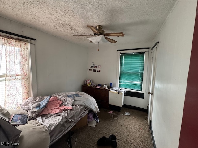 carpeted bedroom with ceiling fan and a textured ceiling