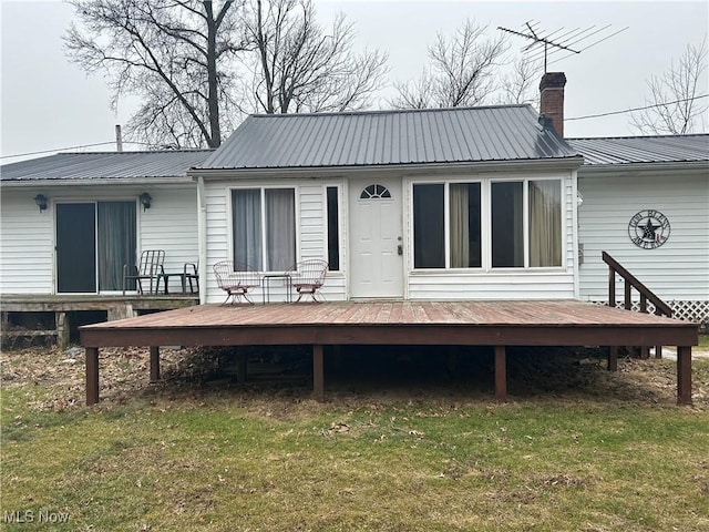 rear view of property featuring a yard and a deck