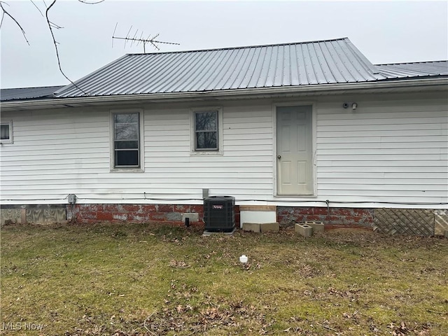 back of house with central AC and a lawn