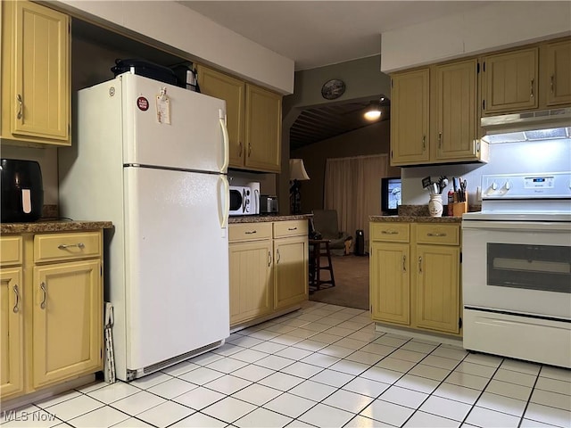 kitchen with light tile patterned flooring, lofted ceiling, and white appliances