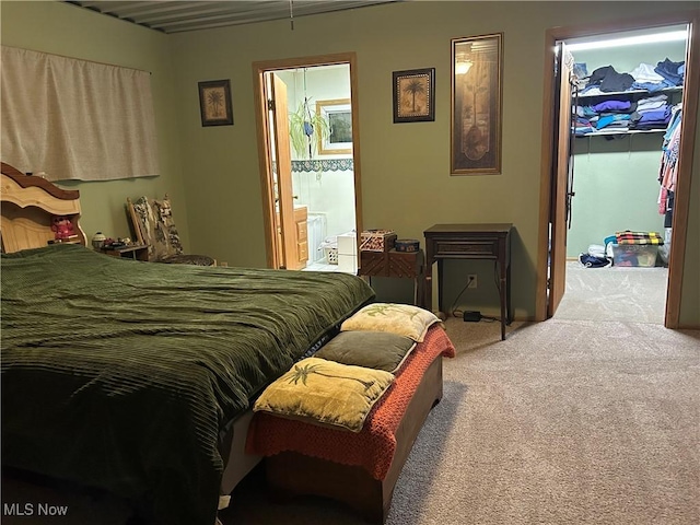 carpeted bedroom with ensuite bathroom, a spacious closet, and a closet