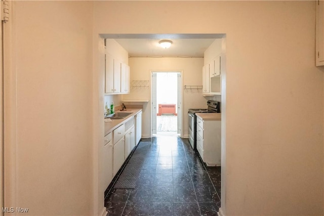 kitchen featuring stainless steel range with electric stovetop, white dishwasher, sink, and white cabinets