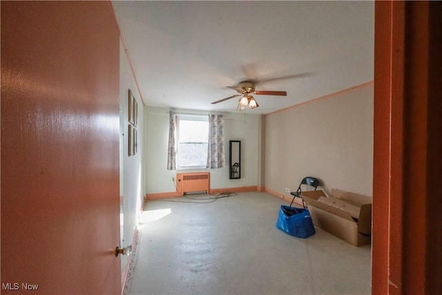 unfurnished room with ceiling fan, concrete flooring, and radiator