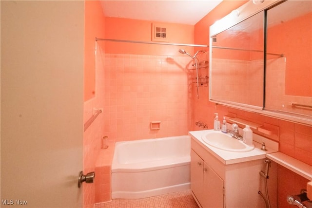 bathroom featuring vanity, tile patterned floors, and tiled shower / bath