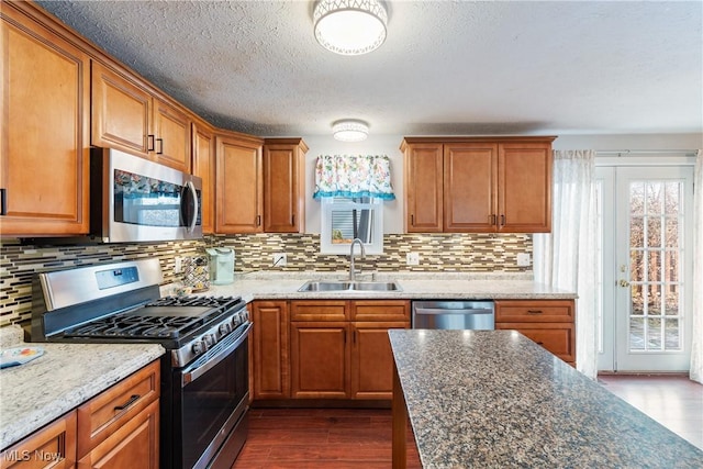 kitchen with stainless steel appliances, sink, dark wood-type flooring, and backsplash