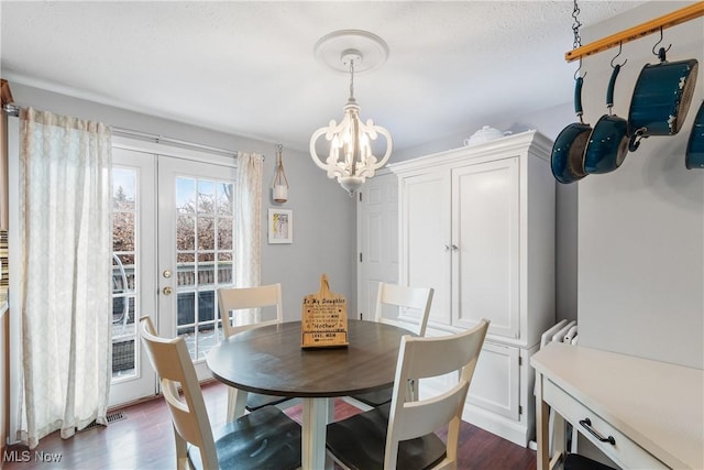 dining room with dark hardwood / wood-style flooring, french doors, and a chandelier