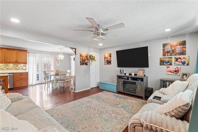 living room with ceiling fan, dark hardwood / wood-style floors, and a textured ceiling