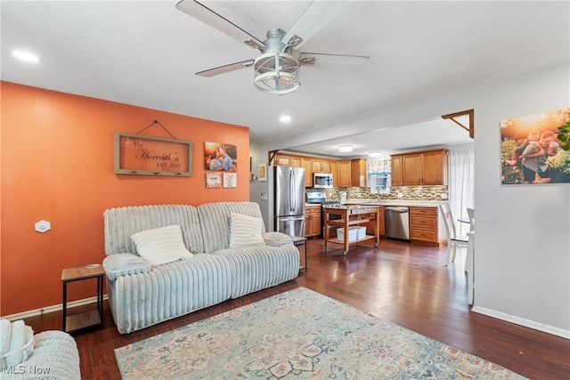 living room featuring ceiling fan and dark hardwood / wood-style flooring