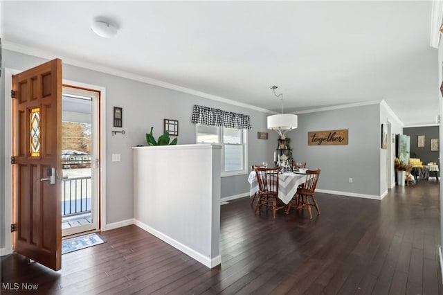 dining space with ornamental molding and dark hardwood / wood-style floors