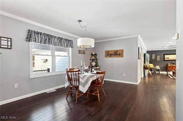 dining room with dark wood-type flooring and crown molding