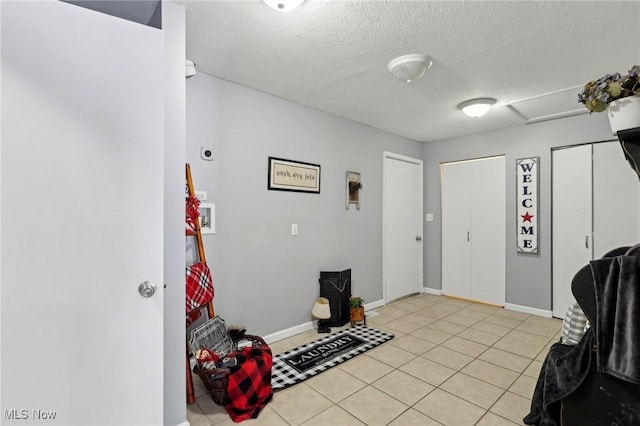 tiled foyer entrance featuring a textured ceiling