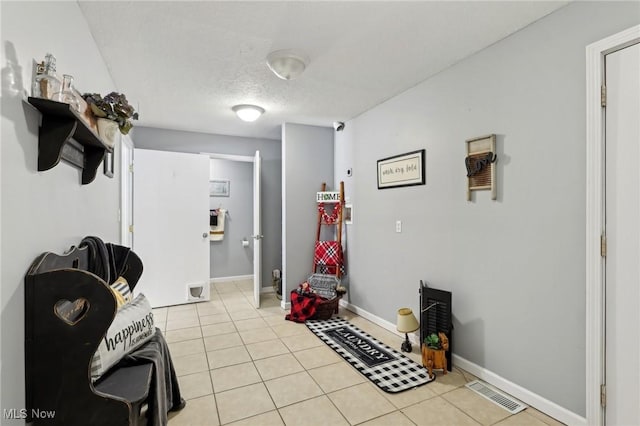 miscellaneous room featuring a textured ceiling and light tile patterned floors