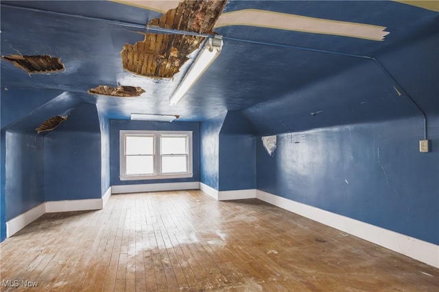 bonus room featuring wood-type flooring and vaulted ceiling