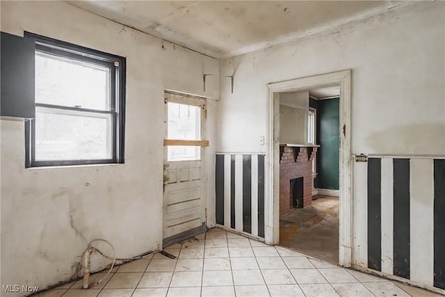 tiled empty room featuring a fireplace