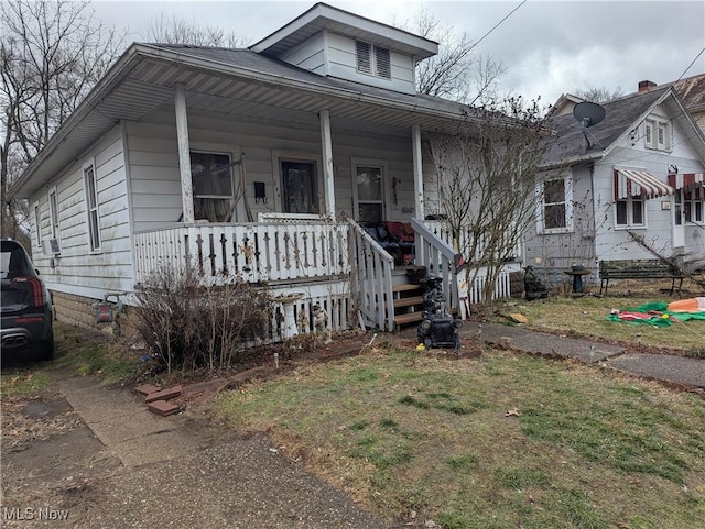 bungalow-style home with a porch and a front lawn