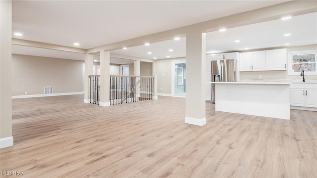 unfurnished living room with sink and light wood-type flooring