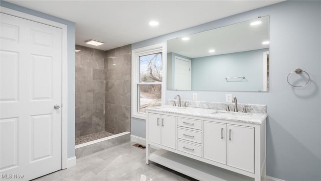 bathroom with vanity and a tile shower