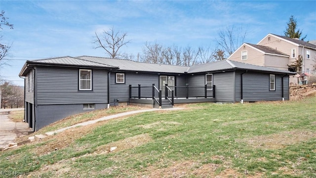 back of house featuring a lawn and a deck