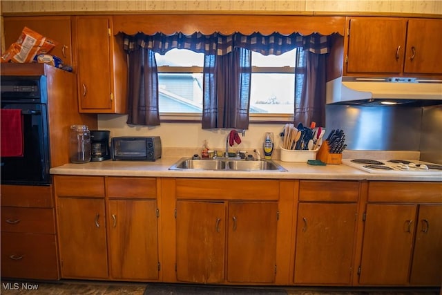 kitchen with white stovetop, sink, and black oven