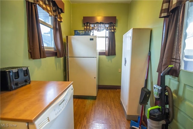 kitchen with white dishwasher, refrigerator, and light hardwood / wood-style floors