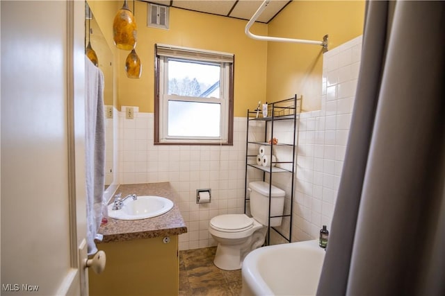 full bathroom featuring vanity, bathtub / shower combination, tile walls, and toilet