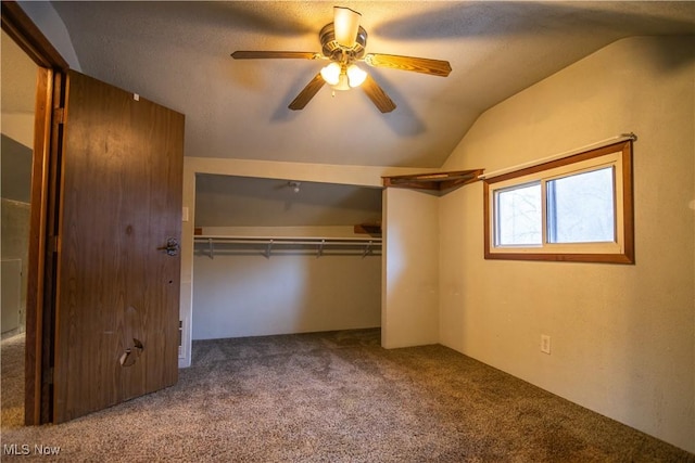 unfurnished bedroom featuring lofted ceiling, carpet, ceiling fan, and a closet