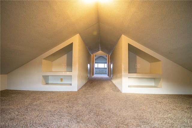 bonus room with lofted ceiling, carpet floors, and a textured ceiling