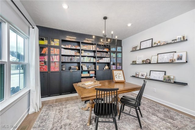 office area featuring baseboards, a chandelier, recessed lighting, wood finished floors, and a textured ceiling