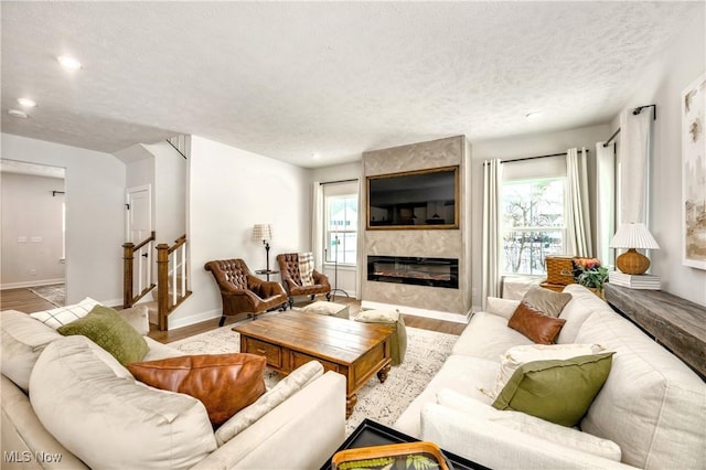 living room with plenty of natural light, a textured ceiling, wood finished floors, and a fireplace