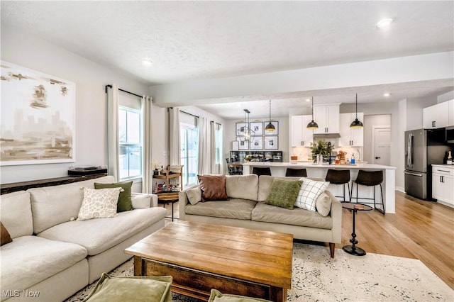 living area featuring light wood-style flooring and recessed lighting