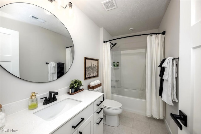 bathroom featuring vanity, tile patterned floors, visible vents, and a textured ceiling