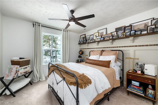 bedroom featuring carpet flooring, a ceiling fan, and a textured ceiling