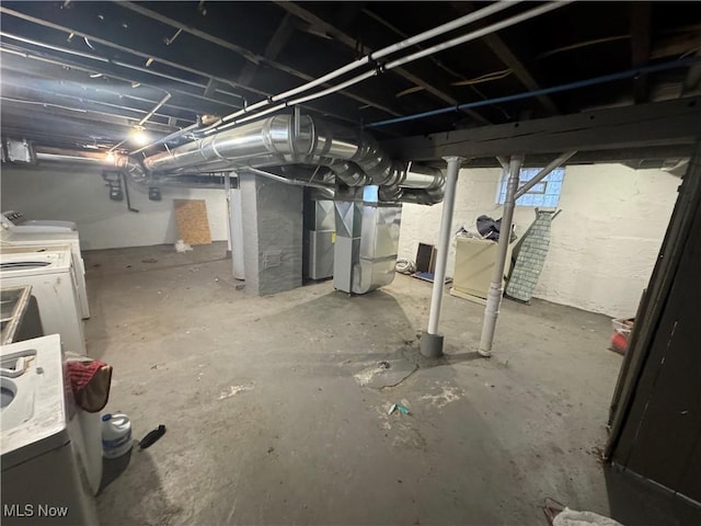 basement with heating unit and washer and clothes dryer