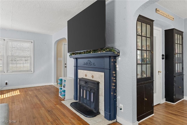 living room with hardwood / wood-style floors, a fireplace, and a textured ceiling