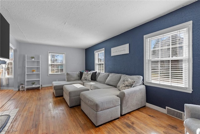 living room with wood-type flooring and a textured ceiling