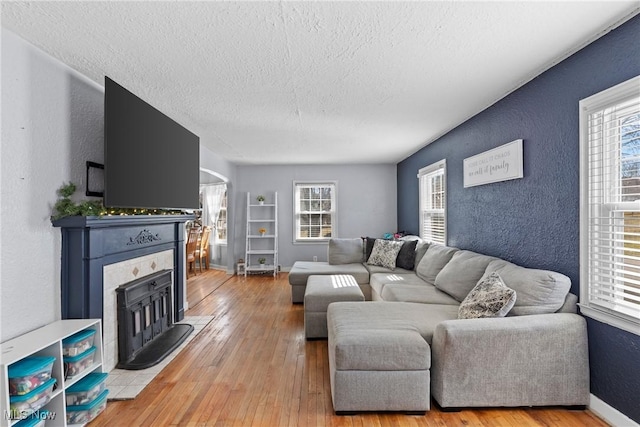 living room with a textured ceiling and light wood-type flooring