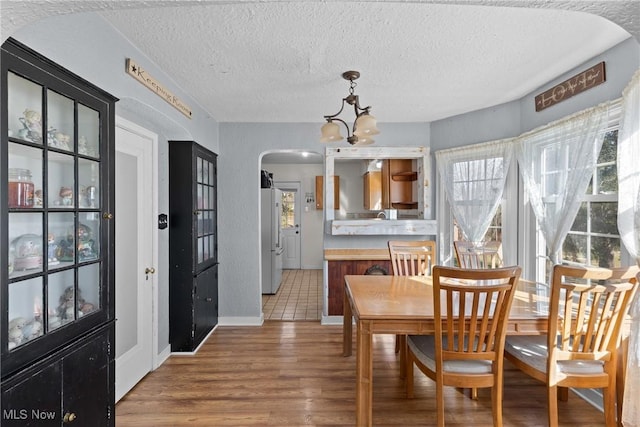 dining area featuring hardwood / wood-style flooring, a chandelier, and a textured ceiling