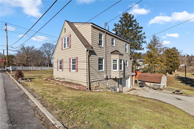 view of side of property with a garage and a lawn