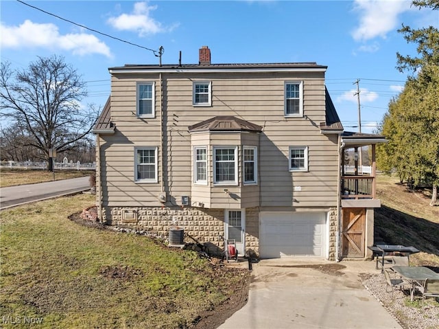 view of front of home featuring a garage, central AC, and a front yard