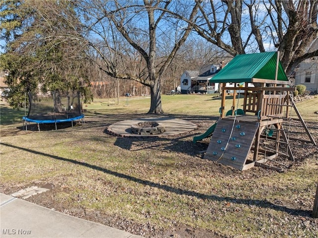 view of playground with a trampoline, a lawn, and an outdoor fire pit