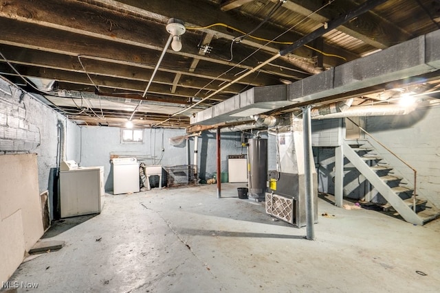 basement with heating unit, washer and dryer, and gas water heater