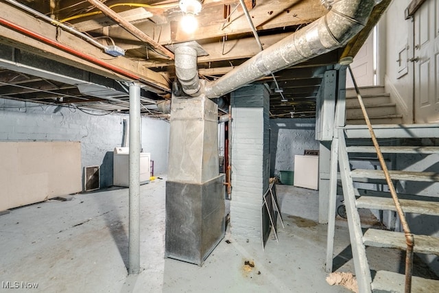 basement featuring washing machine and dryer and heating unit