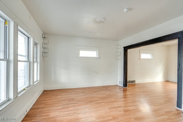 spare room with a healthy amount of sunlight and light hardwood / wood-style flooring